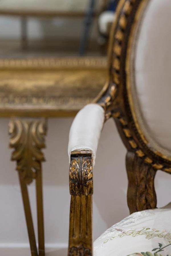 Dettaglio di una poltroncina in stile con intagli dorati