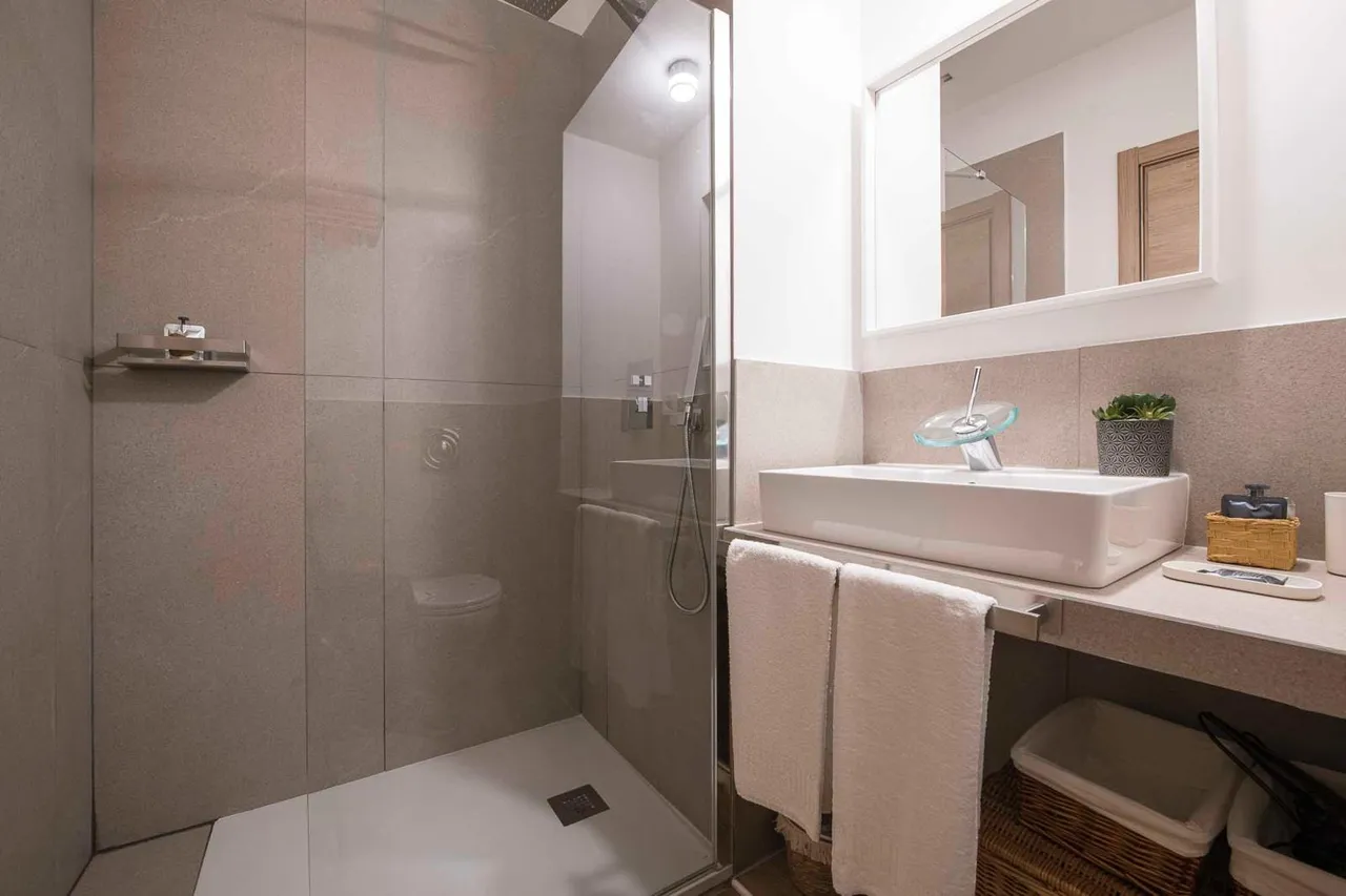 Il bagno, con la doccia in vetro e il lavabo