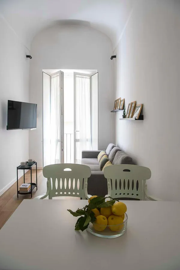 La zona living e pranzo, con i limoni sul tavolo e la porta-finestra in fondo